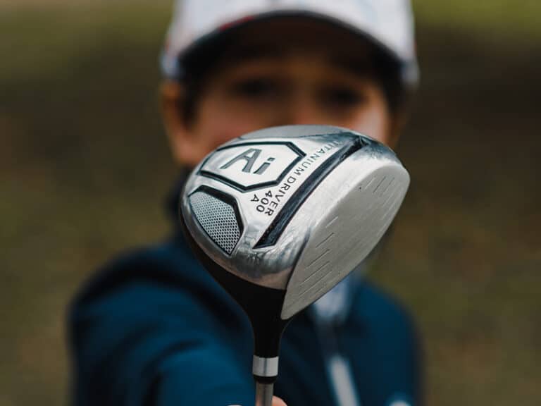 Lynx Junior ai black driver, being held up by a junior golfer.