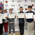 a group of junior golfers all celebrating there certificates at the end of competition.