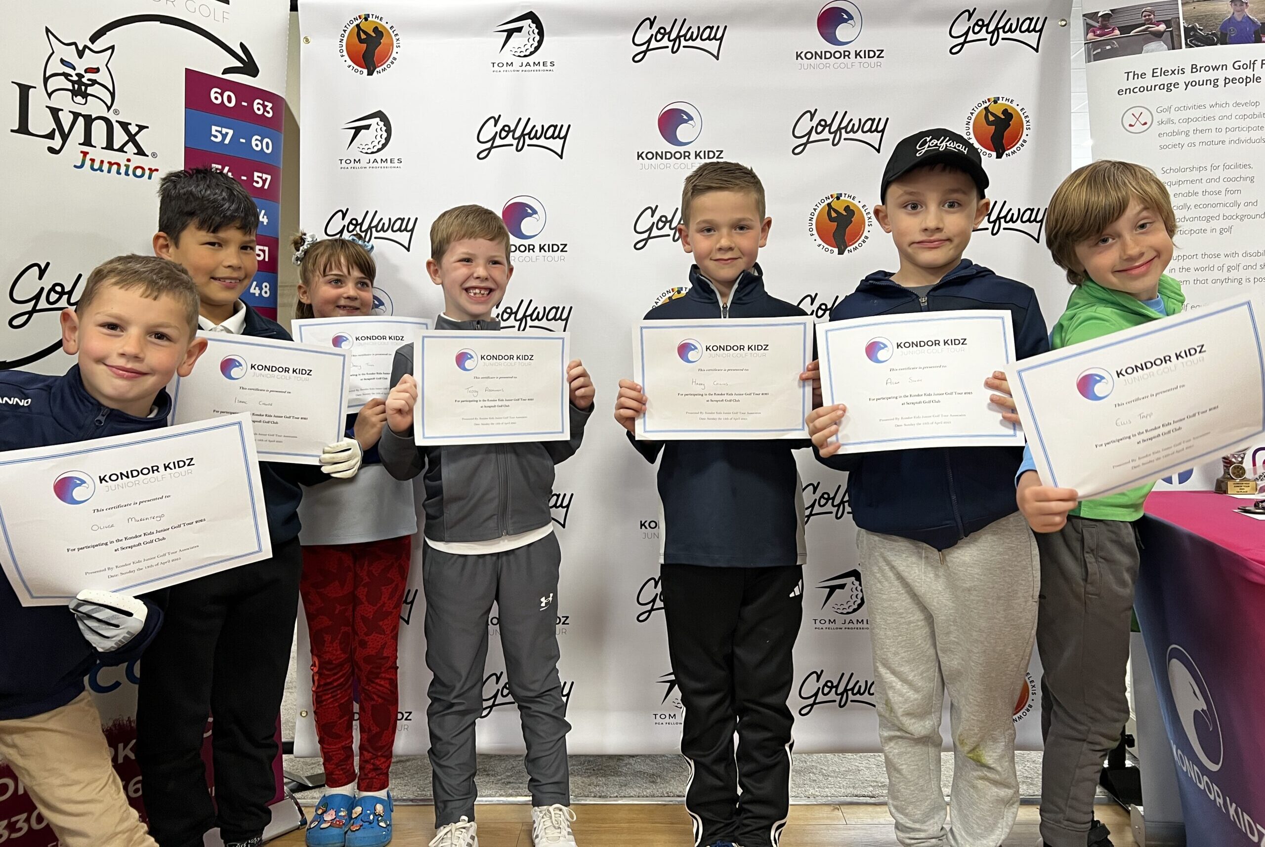 a group of junior golfers all celebrating there certificates at the end of competition.